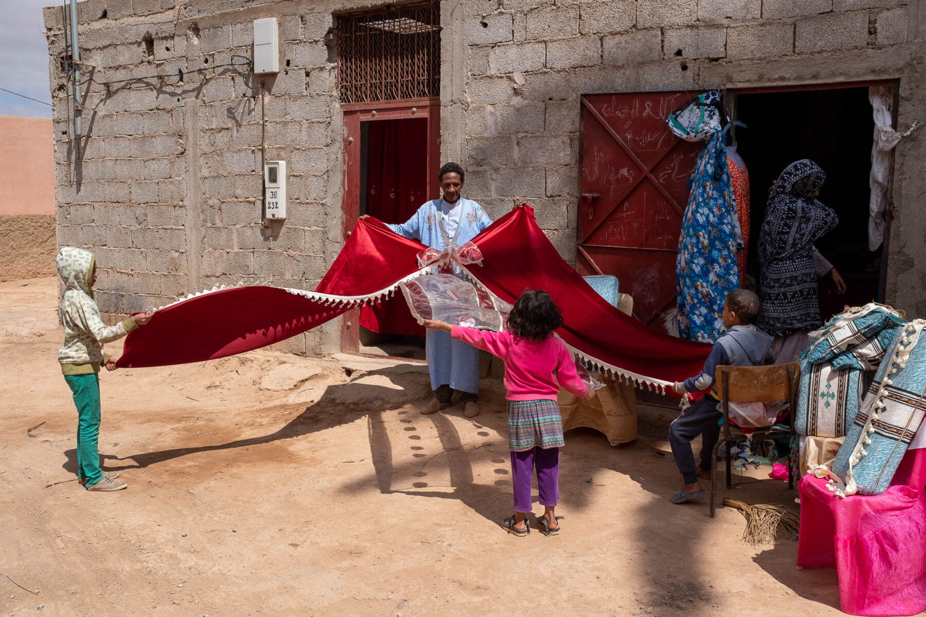 a father and his children holding a red curtain