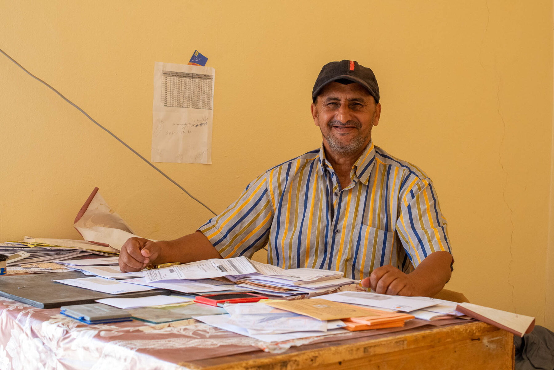 a man sitting at a table with papers, postoffice tighmert