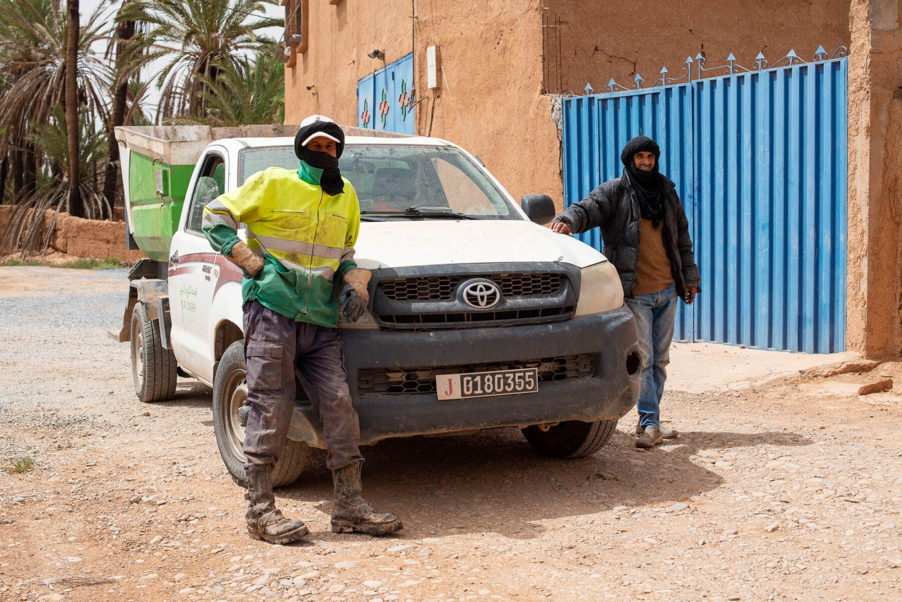 two men standing next to a car