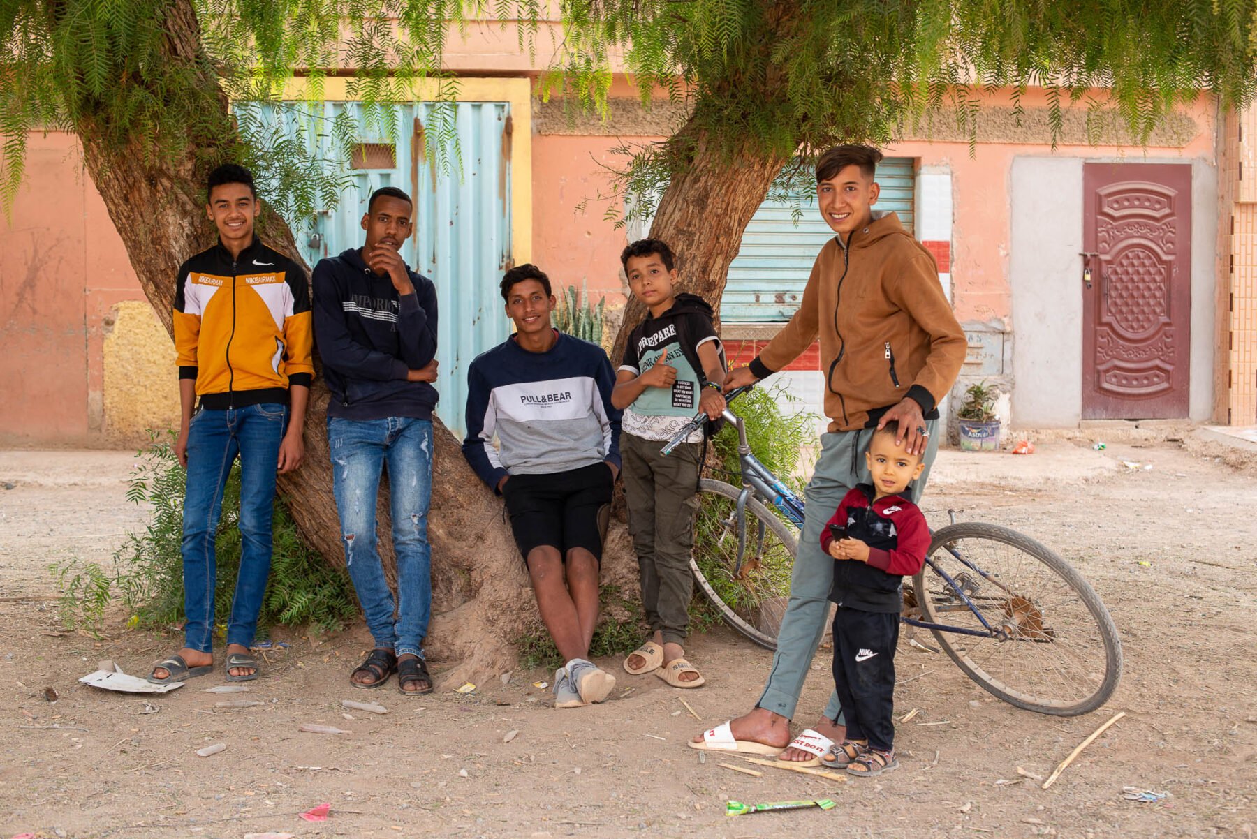 a group of young men standing under a tree